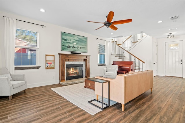 living room with dark wood-type flooring and ceiling fan