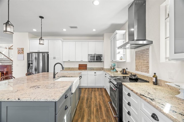 kitchen featuring white cabinets, an island with sink, wall chimney exhaust hood, and appliances with stainless steel finishes