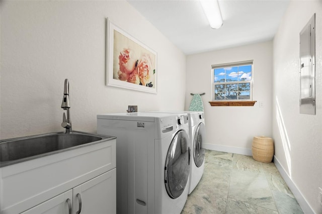 washroom with cabinets, washing machine and dryer, sink, and electric panel