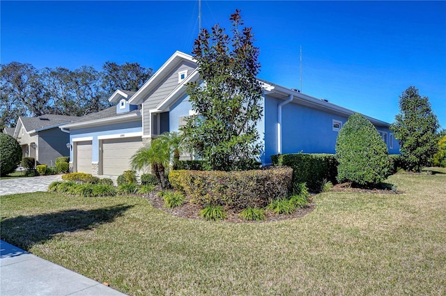 view of property exterior with a garage and a lawn