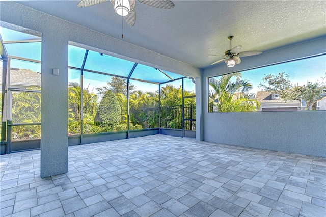 unfurnished sunroom featuring ceiling fan