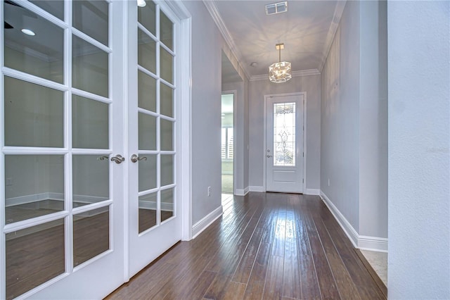 entrance foyer with french doors, ornamental molding, and dark hardwood / wood-style flooring