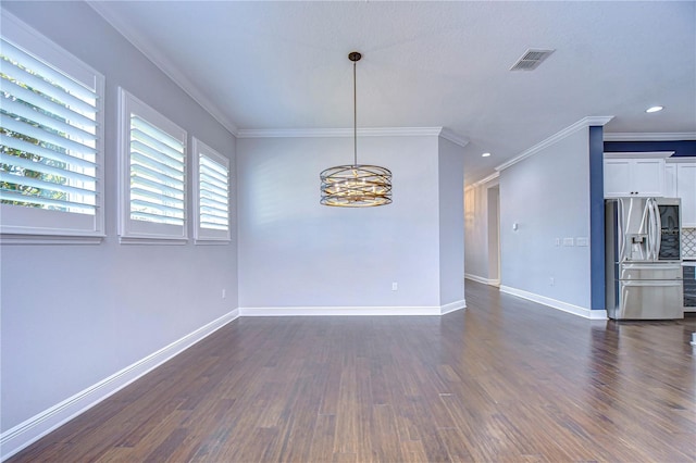 empty room featuring dark wood-type flooring, ornamental molding, and an inviting chandelier