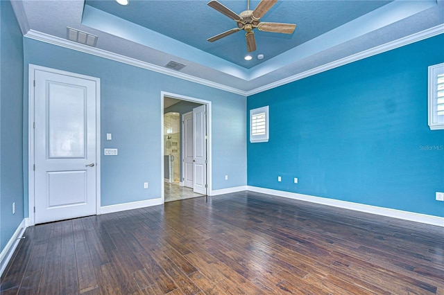 unfurnished room featuring dark hardwood / wood-style flooring, crown molding, a raised ceiling, and ceiling fan