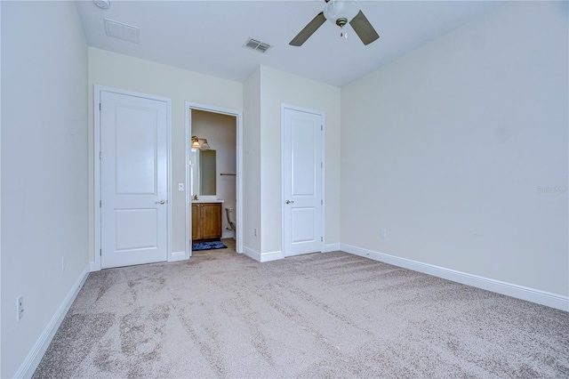 unfurnished bedroom featuring light carpet, connected bathroom, and ceiling fan