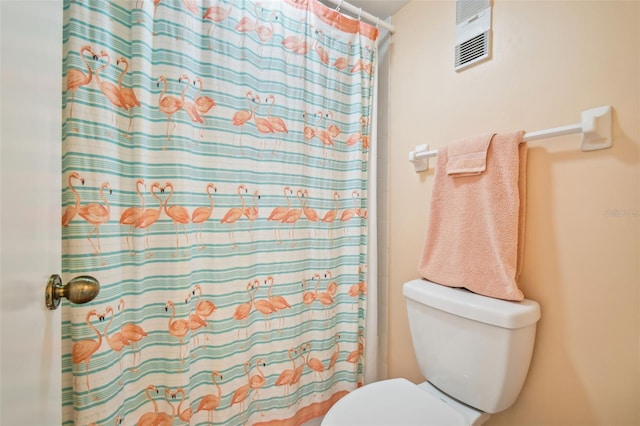 bathroom featuring a shower with curtain and toilet