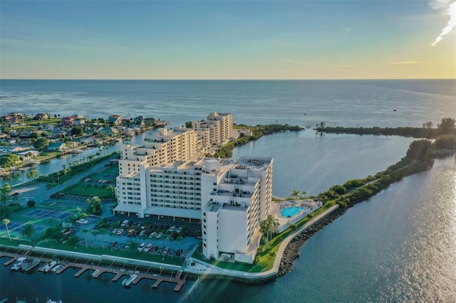 aerial view at dusk featuring a water view