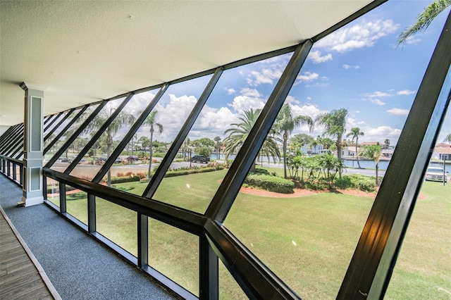 unfurnished sunroom featuring a water view