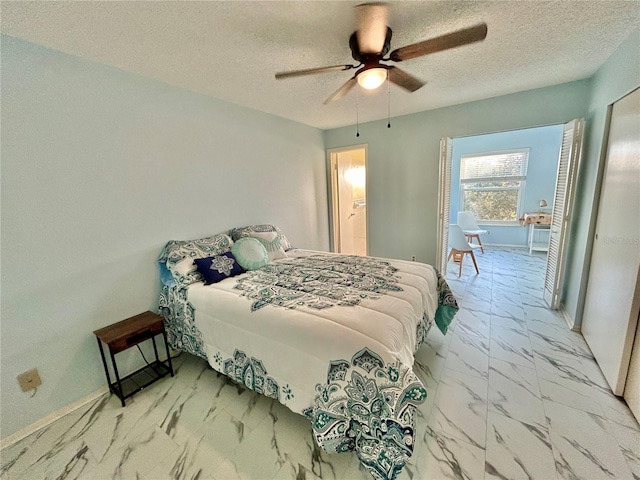 bedroom with ceiling fan and a textured ceiling