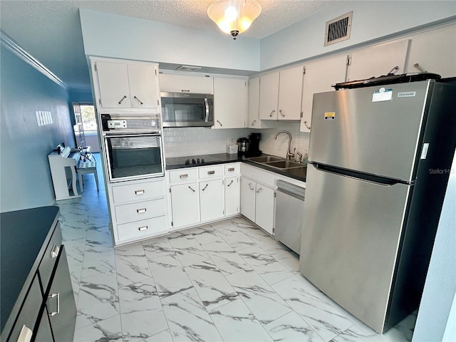 kitchen with sink, white cabinetry, black appliances, a textured ceiling, and decorative backsplash