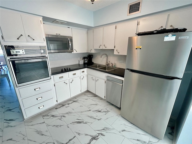 kitchen featuring sink, white cabinetry, tasteful backsplash, a textured ceiling, and black appliances