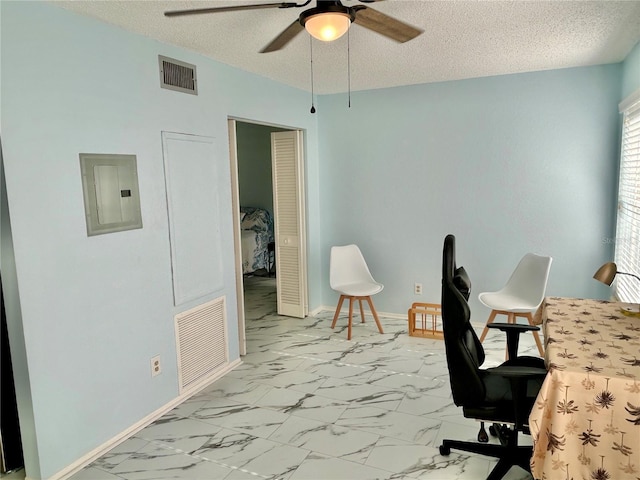 office space featuring ceiling fan, electric panel, and a textured ceiling