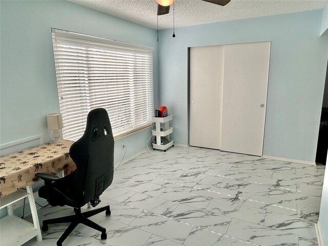 home office with ceiling fan and a textured ceiling