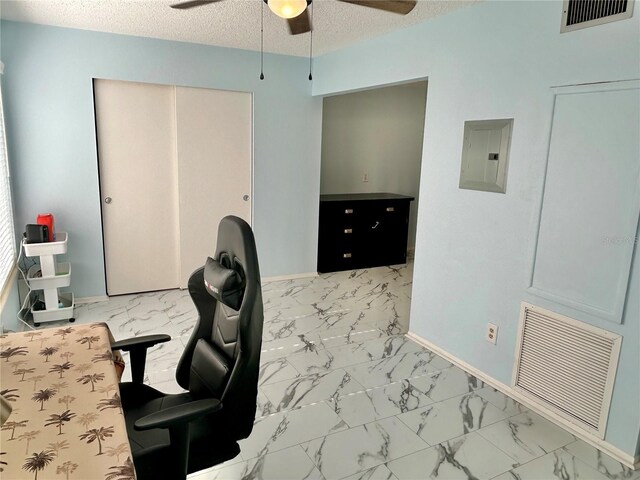 home office featuring ceiling fan, electric panel, and a textured ceiling