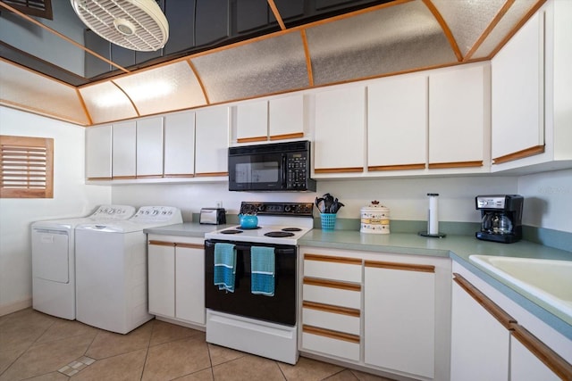 kitchen with electric range oven, sink, white cabinets, light tile patterned floors, and washer and clothes dryer