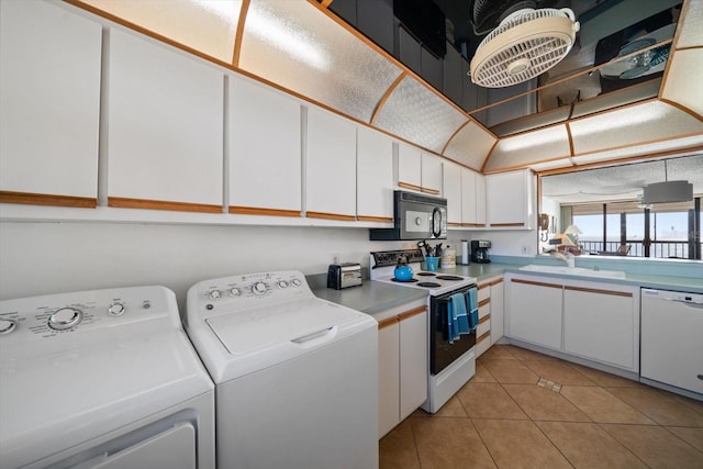 clothes washing area featuring sink, light tile patterned floors, and washer and clothes dryer