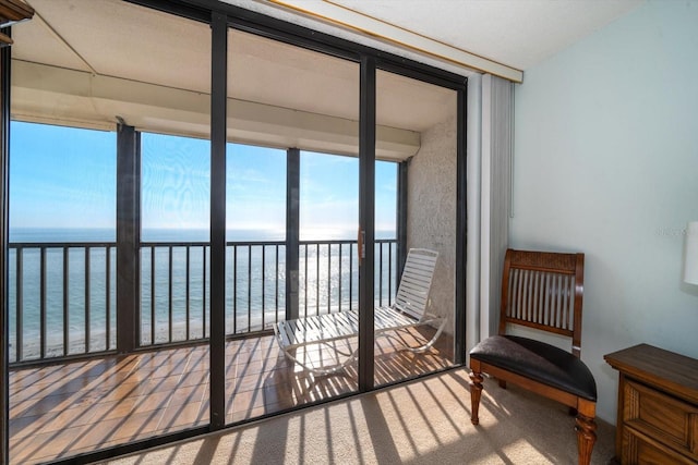 sunroom / solarium featuring a water view and a beach view