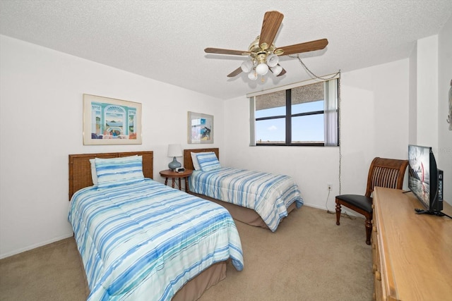 bedroom featuring light carpet, ceiling fan, and a textured ceiling