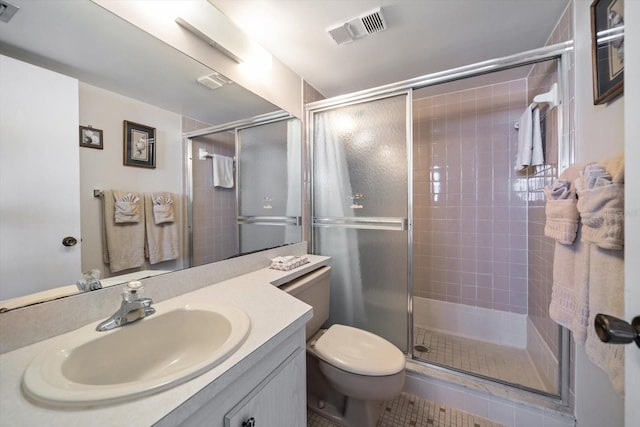 bathroom with tile patterned floors, vanity, toilet, and a shower with door