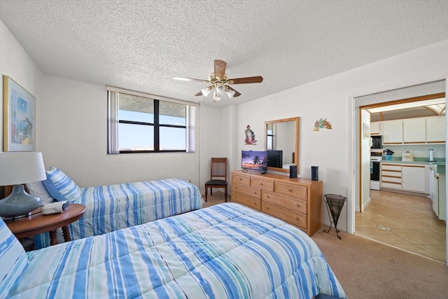 bedroom with ceiling fan, light carpet, and a textured ceiling