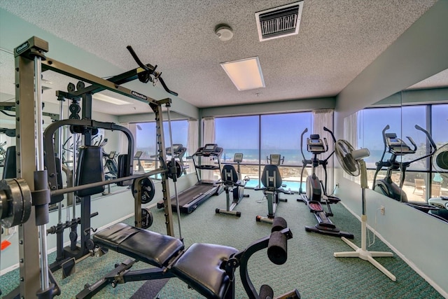 gym with plenty of natural light and a textured ceiling