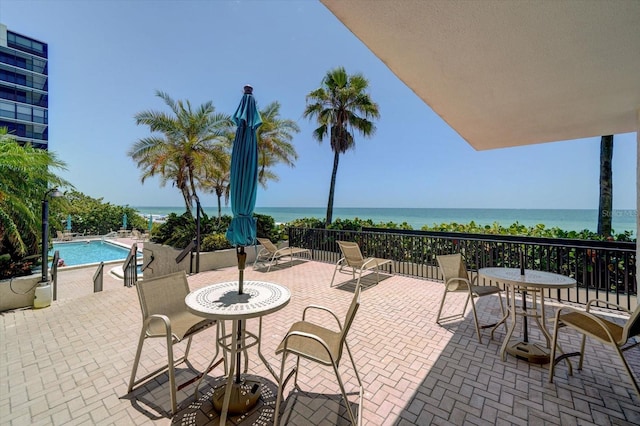 view of patio with a water view and a community pool