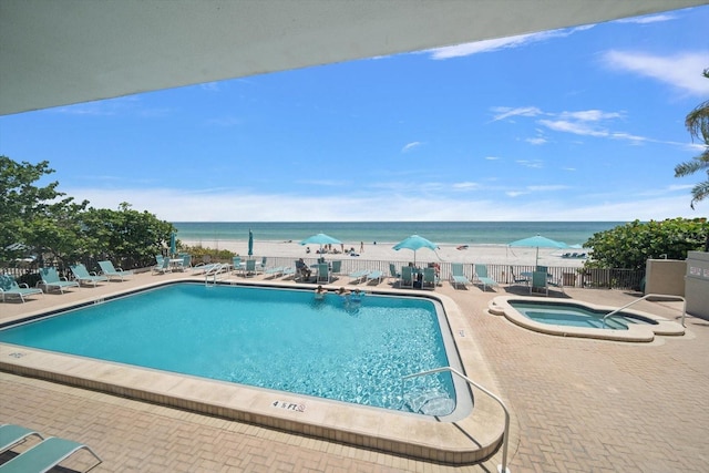 view of swimming pool with a patio area, a community hot tub, and a water view