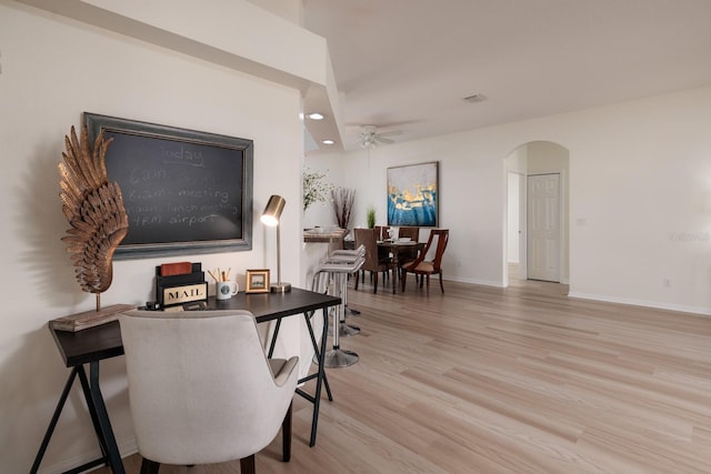 home office with light hardwood / wood-style floors and ceiling fan