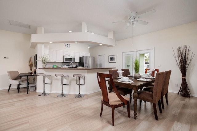 dining space featuring french doors, ceiling fan, and light wood-type flooring