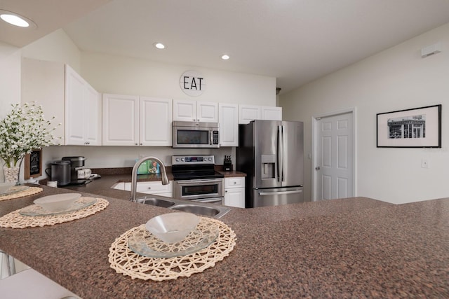 kitchen featuring sink, a breakfast bar area, white cabinetry, kitchen peninsula, and stainless steel appliances