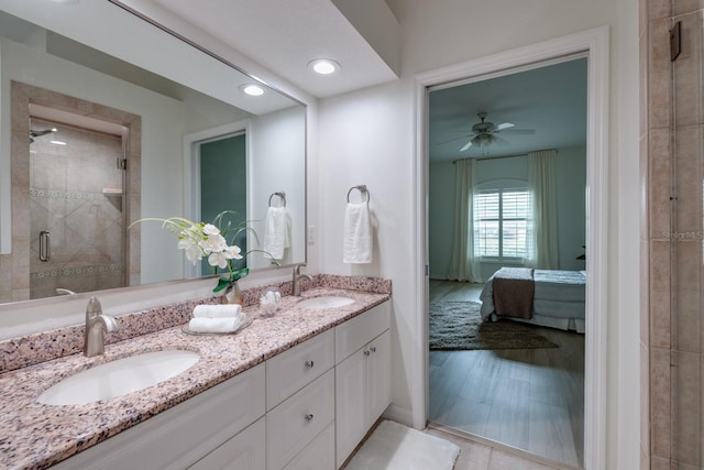 bathroom with vanity, a shower with door, and ceiling fan