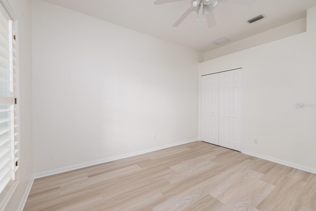 unfurnished bedroom with ceiling fan, light hardwood / wood-style floors, and a closet