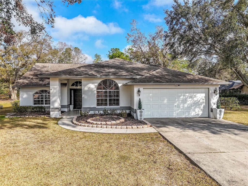 single story home featuring a garage and a front yard