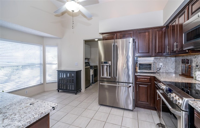 kitchen featuring dark brown cabinets, stainless steel appliances, light stone counters, light tile patterned flooring, and decorative backsplash