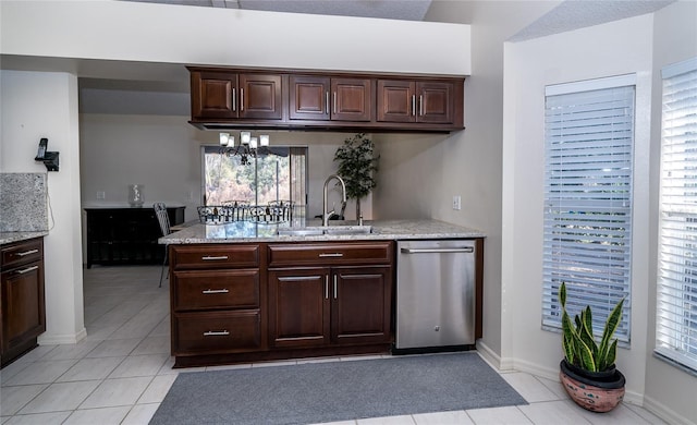 kitchen with dishwasher, dark brown cabinets, sink, and light tile patterned floors