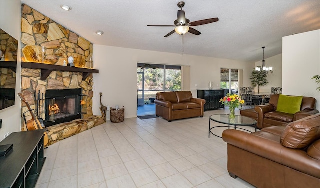 living room with lofted ceiling, a stone fireplace, ceiling fan with notable chandelier, and a textured ceiling