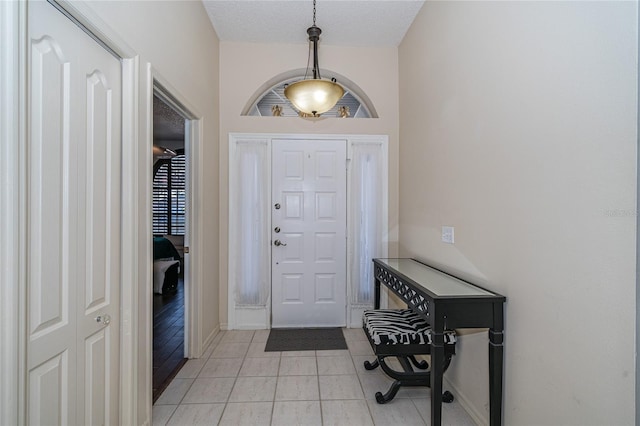 tiled foyer with a textured ceiling