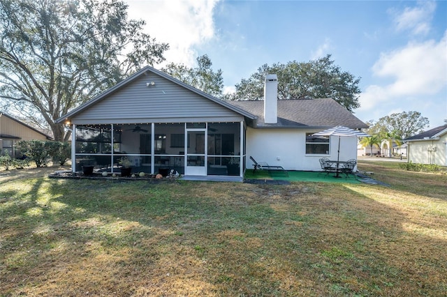 rear view of property with a yard and a sunroom