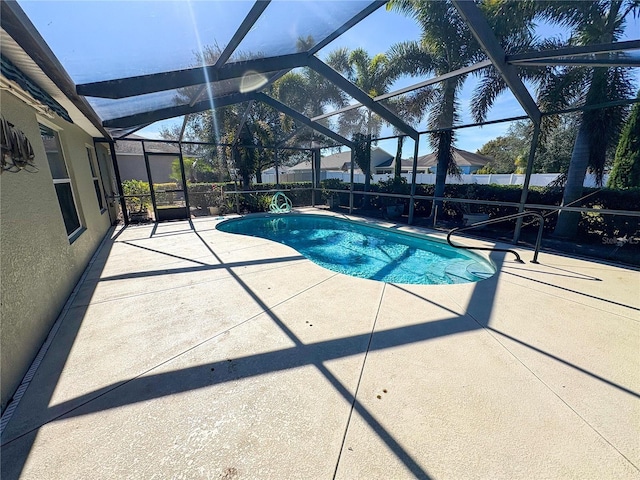 view of swimming pool featuring a patio and glass enclosure