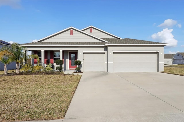 view of front of home featuring a garage, covered porch, and a front yard