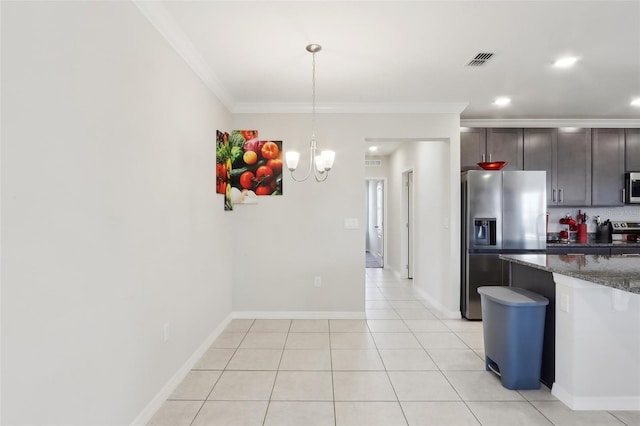 kitchen featuring crown molding, decorative light fixtures, dark brown cabinets, dark stone countertops, and appliances with stainless steel finishes