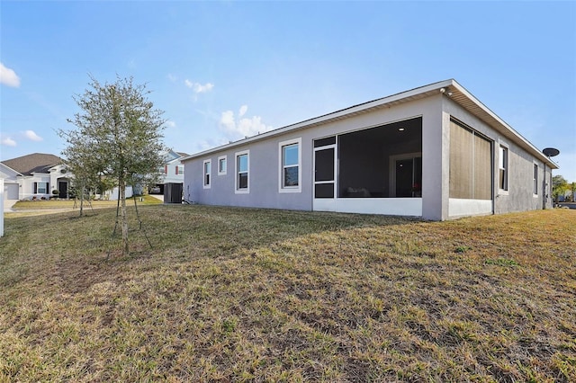 back of house featuring a lawn and central air condition unit