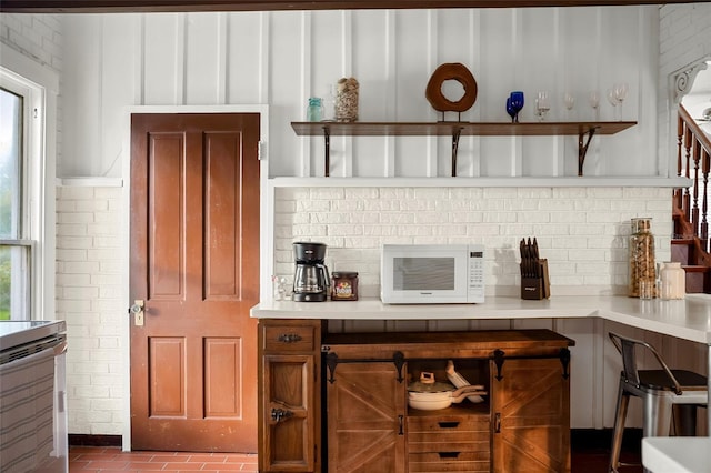 bar featuring backsplash and range with electric cooktop