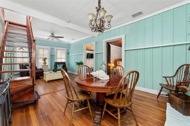 dining space featuring hardwood / wood-style floors, beam ceiling, and ceiling fan with notable chandelier