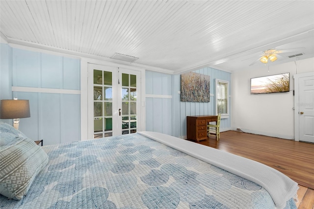 bedroom featuring multiple windows, hardwood / wood-style floors, ceiling fan, and french doors