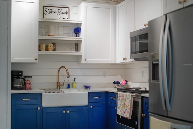 kitchen featuring white cabinetry, appliances with stainless steel finishes, blue cabinets, and sink