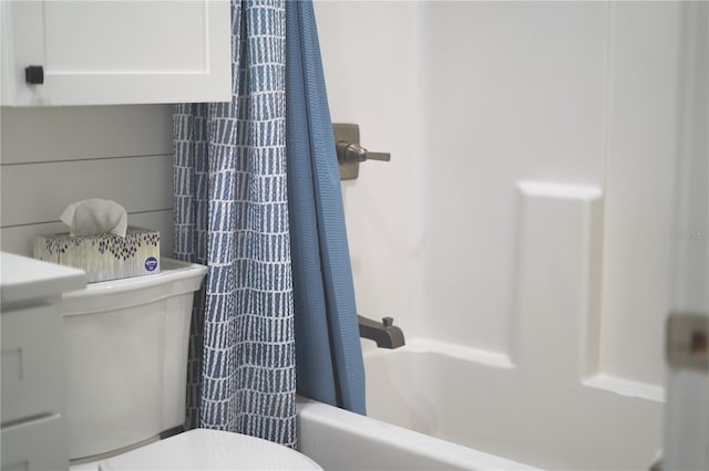 bathroom featuring shower / tub combo with curtain and toilet