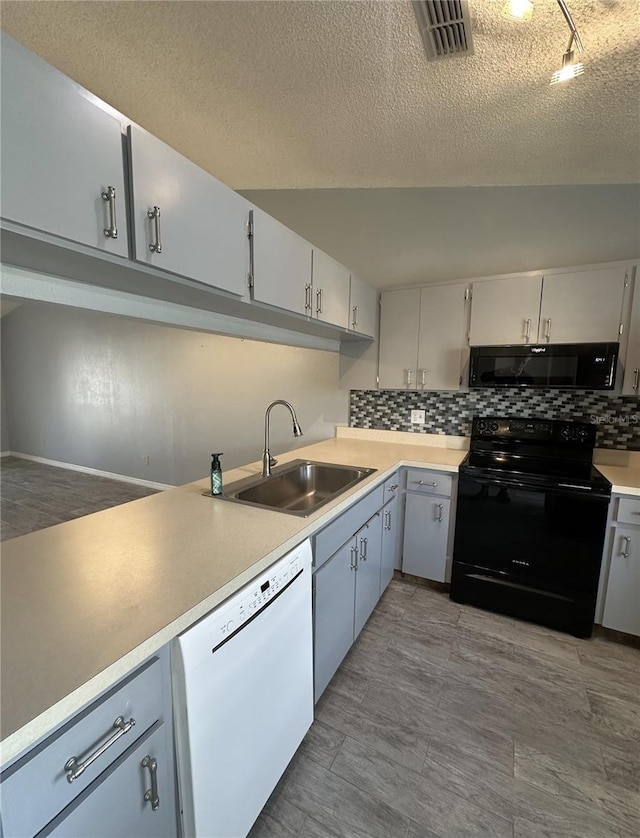 kitchen featuring tasteful backsplash, sink, a textured ceiling, and black appliances