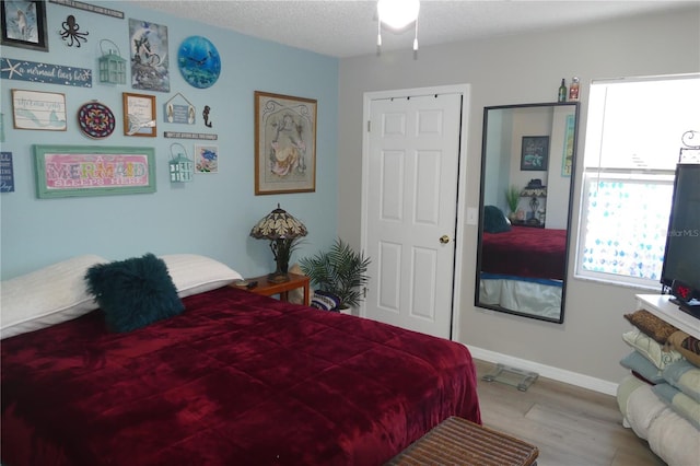 bedroom with light hardwood / wood-style floors and a textured ceiling