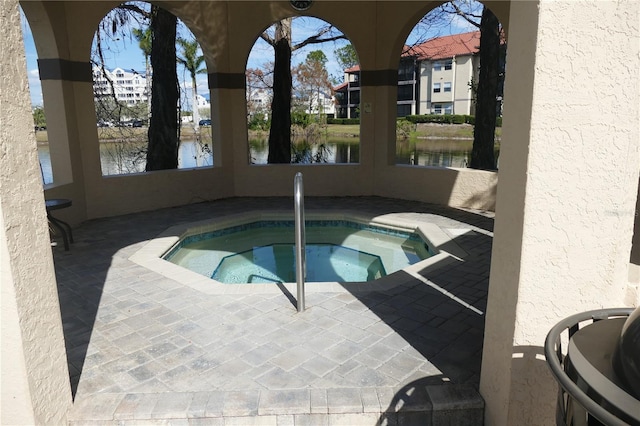 view of swimming pool featuring a water view, a patio area, and a community hot tub